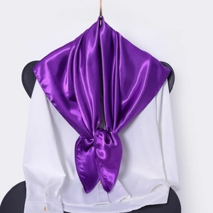 Detail view of a purple satin silk square scarf tied elegantly over a white shirt collar