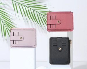 Detailed view of pink, purple and black PU leather card holders with zippers and snap buttons