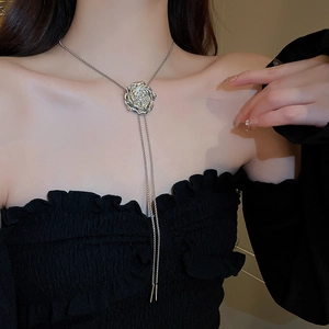 Detailed view of silver rose bolo tie necklace with 3D petals on a model
