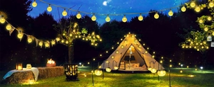 Solar powered warm white globe string lights illuminating a cozy outdoor campsite at night