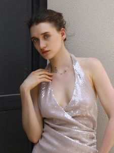 Close-up of 18K gold plated heart necklace on a model wearing a pink sequin top
