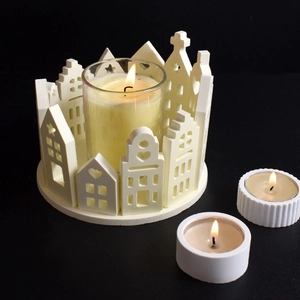 Detailed view of a white ceramic house candle holder with glass cup on a dark background