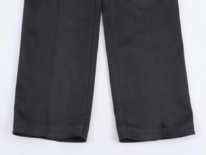Dettaglio ravvicinato dell'orlo dei pantaloni da completo in raso nero con cuciture