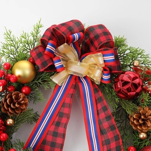 Christmas wreath with pine cones, red berries and plaid bow on white background