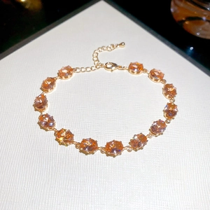 Detail of gold bracelet with fourteen oval-cut champagne zircons and lobster clasp closure