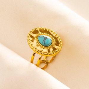 Detail of golden stainless steel ring with teardrop turquoise and hollow band texture