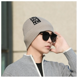 Close-up of khaki ribbed knit beanie for men featuring a FARD logo patch detail