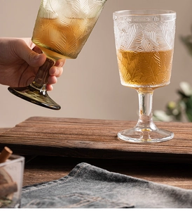 Detail of vintage embossed wine glasses with leaf pattern on a wooden table