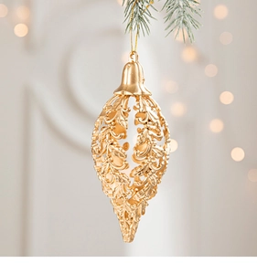 Close-up of golden hollowed Christmas star pendant with intricate floral relief and warm bokeh