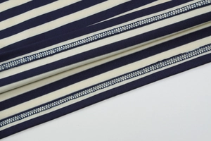 Nahaufnahme von gestreiftem Strickstoff in Marine und Creme mit hochwertigen Nähten