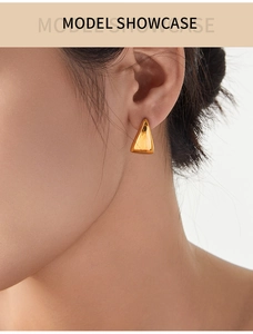 Polished gold triangle geometric stud earrings shown on model for a minimalist look