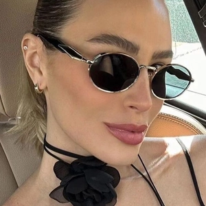Chic oval metal sunglasses with silver frame and black lenses worn by female model