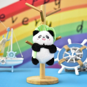 Detail shot of a cute panda plush keychain hanging on a wooden decorative display stand