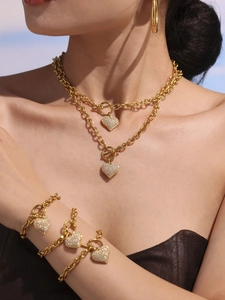 Modella che indossa una collana a cuore multistrato in acciaio dorato con zirconi 5A