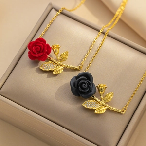 Detailed macro of red and black rose pendants with gold chains in a beige jewelry box