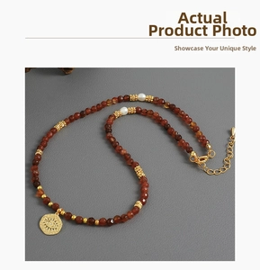 Detail of beaded necklace with freshwater pearls and evil eye gold coin pendant