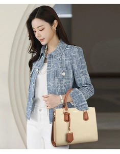 Detail of beige and brown PU leather handbag styled with a blue tweed jacket and pearl buttons