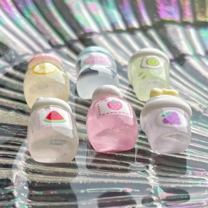 Macro shot of 6 assorted mini resin fruit juice bottles with glitter for DIY crafts