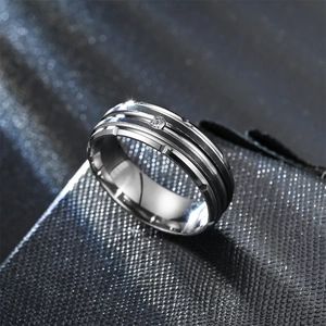 Macro shot of silver titanium steel ring with black stripes and a center crystal stone