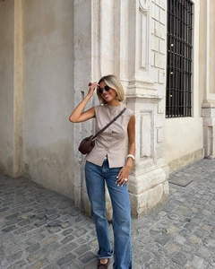 Gilet senza maniche scozzese beige chic abbinato a jeans in uno stile urbano europeo
