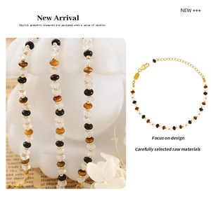 Détail d'un bracelet en perles d'oeil de tigre avec une chaîne d'extension dorée