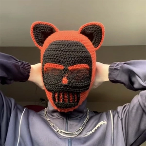 Detail of handmade crochet balaclava featuring cat ears and red-black skull design