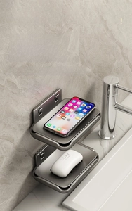 Close-up of wall-mounted gun grey aluminum soap dish with phone shelf and drainage