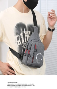 Detail of grey crossbody sling bag with multiple zippers and cartoon music print