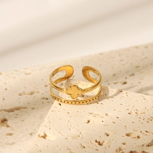 Macro shot of double-layer gold crown ring with clover design on stone background