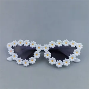 Detailed close-up of daisy flower frames on girls' sunglasses with dark protective lenses