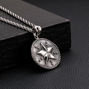 Détail du pendentif étoile vintage argentée avec motifs sur chaîne torsadée