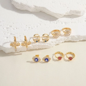 Evil eye geometric gold earrings set with blue zircon crystals and enamel details