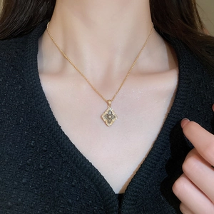 Close-up of a gold-plated vintage clover diamond pendant necklace on a model