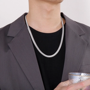 Silver 8mm herringbone flat snake chain necklace worn by a man in a gray suit jacket