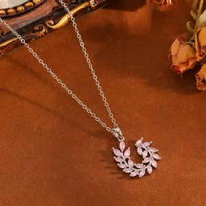 Macro shot of silver leaf pendant with pink marquise zircon and delicate chain