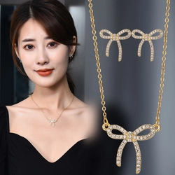 Close-up of golden bow-shaped jewelry set with sparkling crystals on model and details
