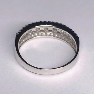 Macro detail of silver ring featuring triple row pavé-set zircons and polished band