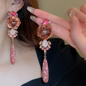 Detailansicht der Roségold-Ohrringe mit Blumenmuster, Kristallen und rosa Anhängern