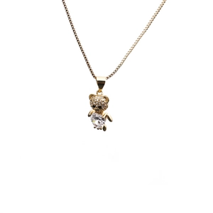 Collier avec pendentif ours doré et zircone cubique en forme de cœur sur fond blanc