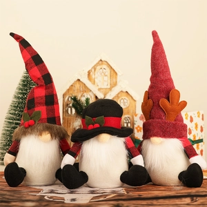 Three Nordic Christmas gnomes with plaid hats and white beards on a festive wood table