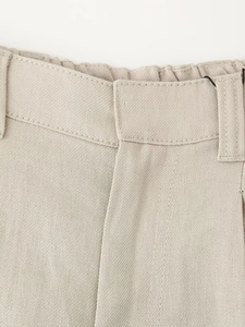 Close-up of beige trousers featuring detailed waist stitching and belt loops