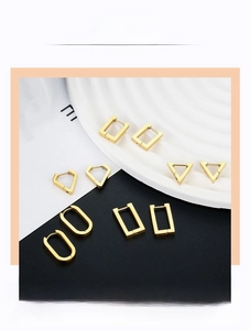 Detail shot of various geometric gold stainless steel earrings on a display stand