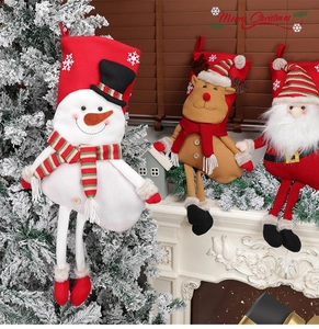 Three 3D plush Christmas stockings hanging on a fireplace mantel with festive decor