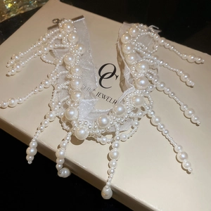 Detailed close-up of mesh tassel pearl choker with elegant fringe on jewelry gift box