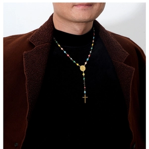 Detailed view of Turkish Evil Eye necklace with Virgin Mary and cross charm on a model