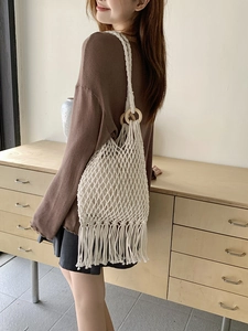 Minimalist summer woven tote bag with fringe tassels and wooden handles for beach holidays