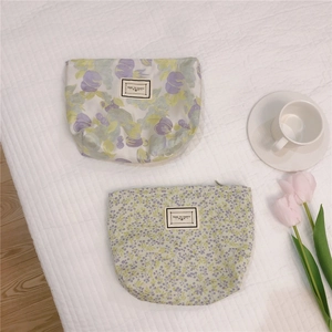 Floral cotton canvas pouches with zipper and embossed label on soft quilted texture