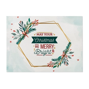 Close-up of linen placemat featuring watercolor pine leaves and Christmas text