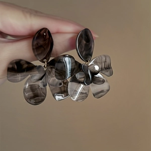Macro detail of chic black resin flower earrings showing semi-transparent petals