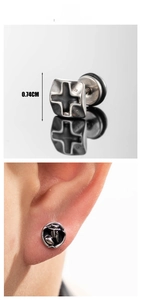 Macro detail of punk titanium steel square cross earring and round eagle claw stud